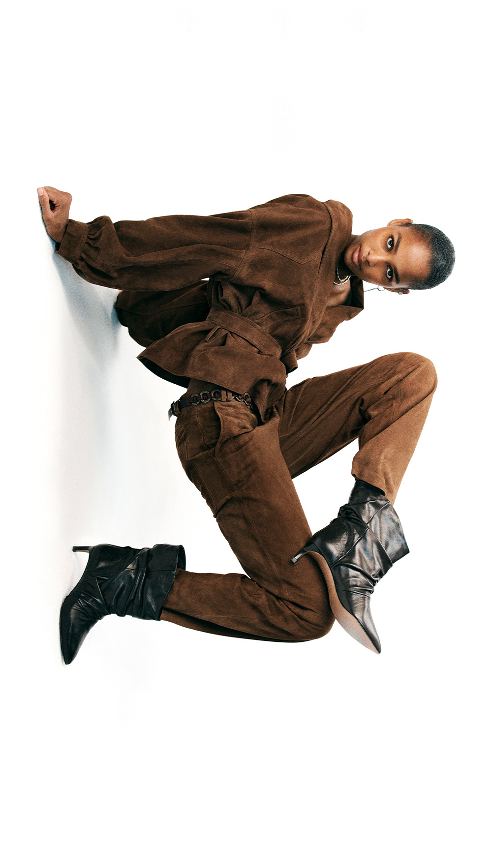 The model is wearing a brown suede jacket
